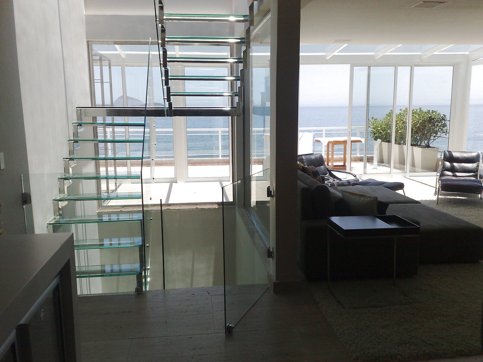 Escada de vidro com vista para o mar